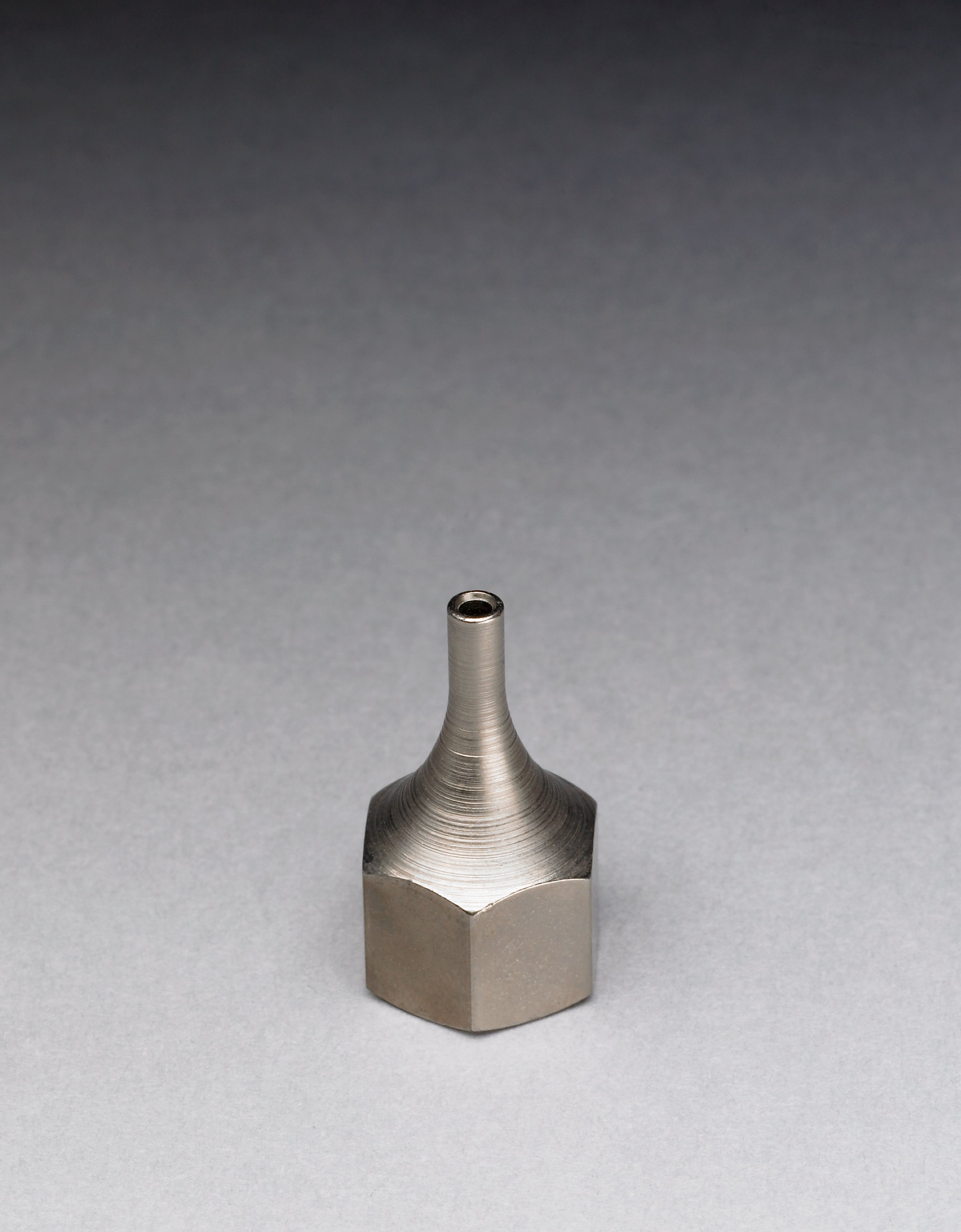 A mini aluminum tip designed to provide a precise and controlled flow of hot melt into hard-to-reach areas, including corners.