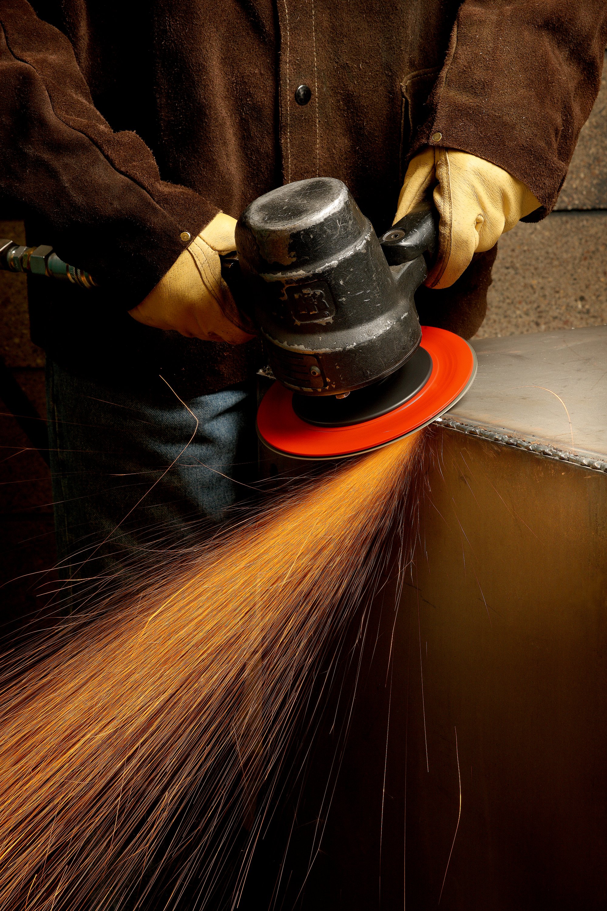 Operator grinding corner weld with a flap disc